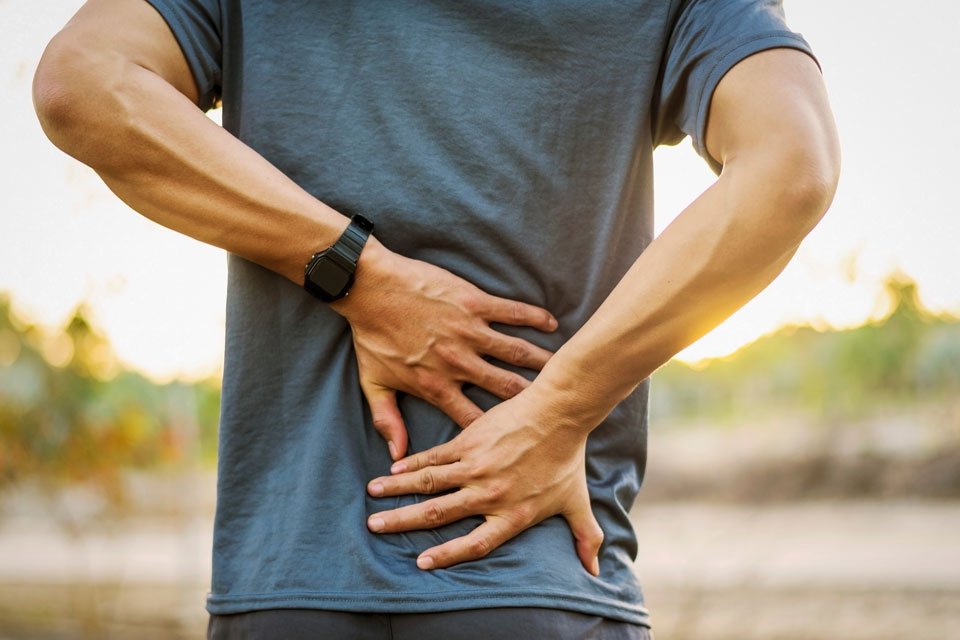 man experiencing back pain an is in need of a massage therapy